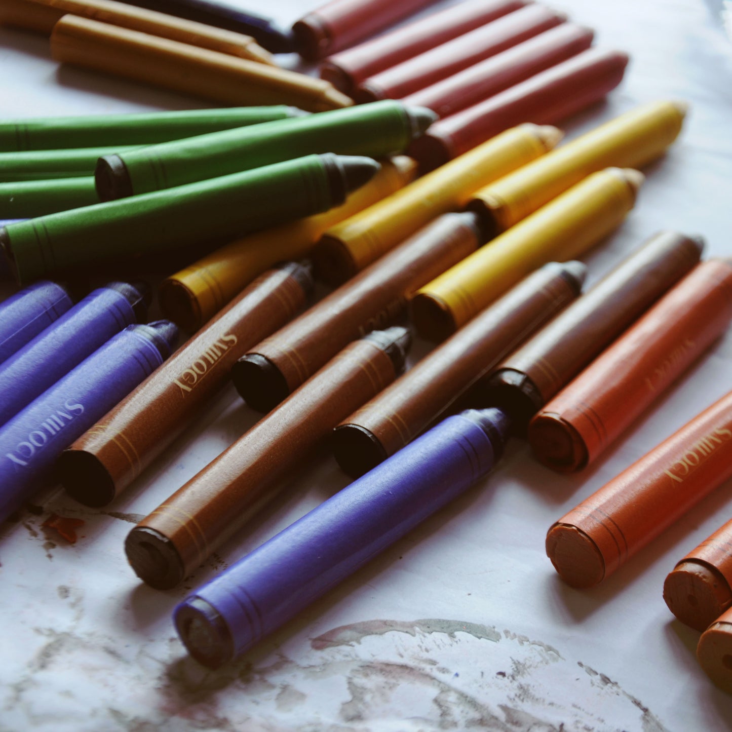 all natural beeswax crayons for kids spread on a white paper surface