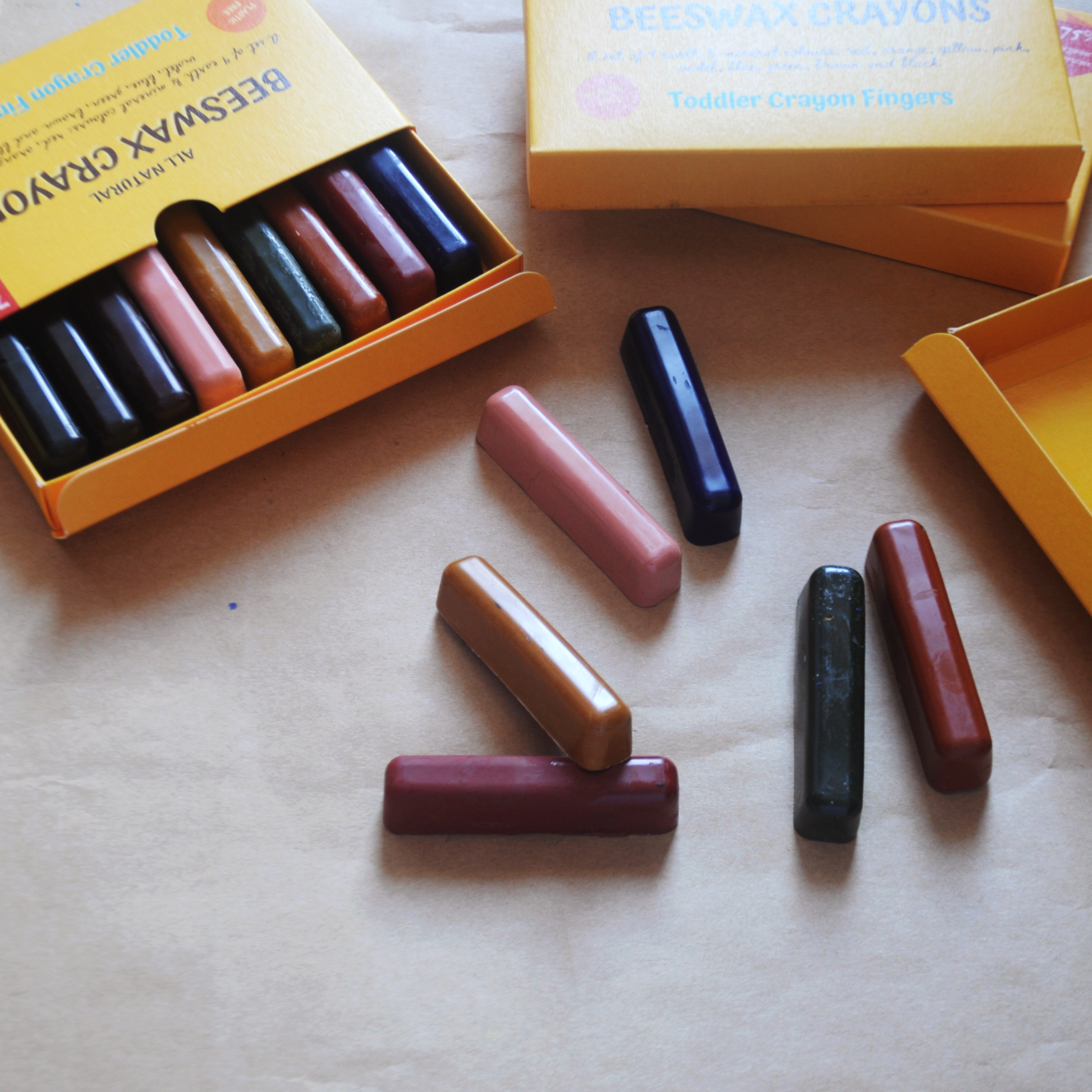 beeswax natural nontoxic finger crayons  for kids flat lay of crayons out of their case with sets of crayons nearby