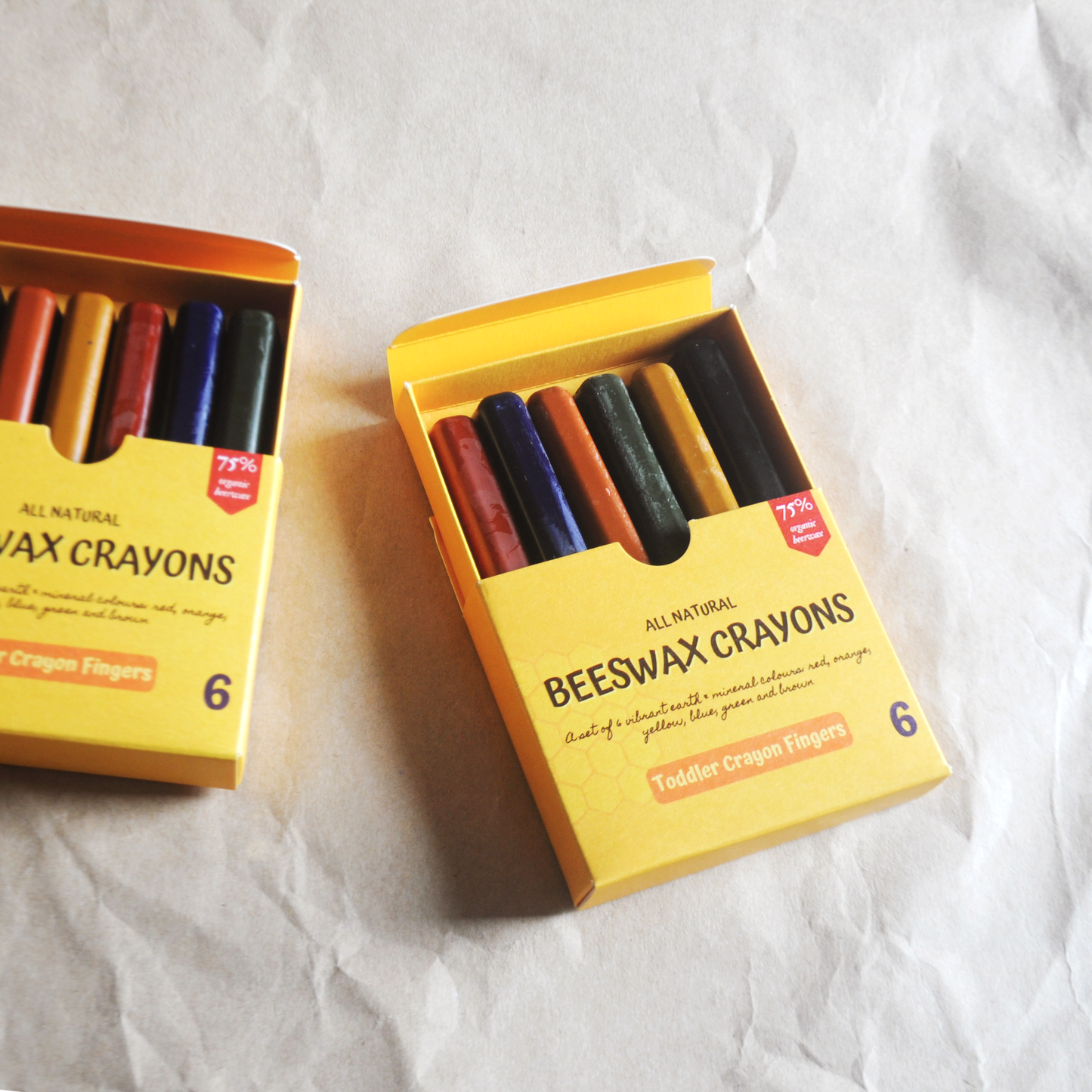 SETS OF BEESWAX CRAYONS FINGERS FOR TODDLERS IN THE  OPEN BOXES FLAT LAY WITH CRAYON BOXES IN BACKGROUND