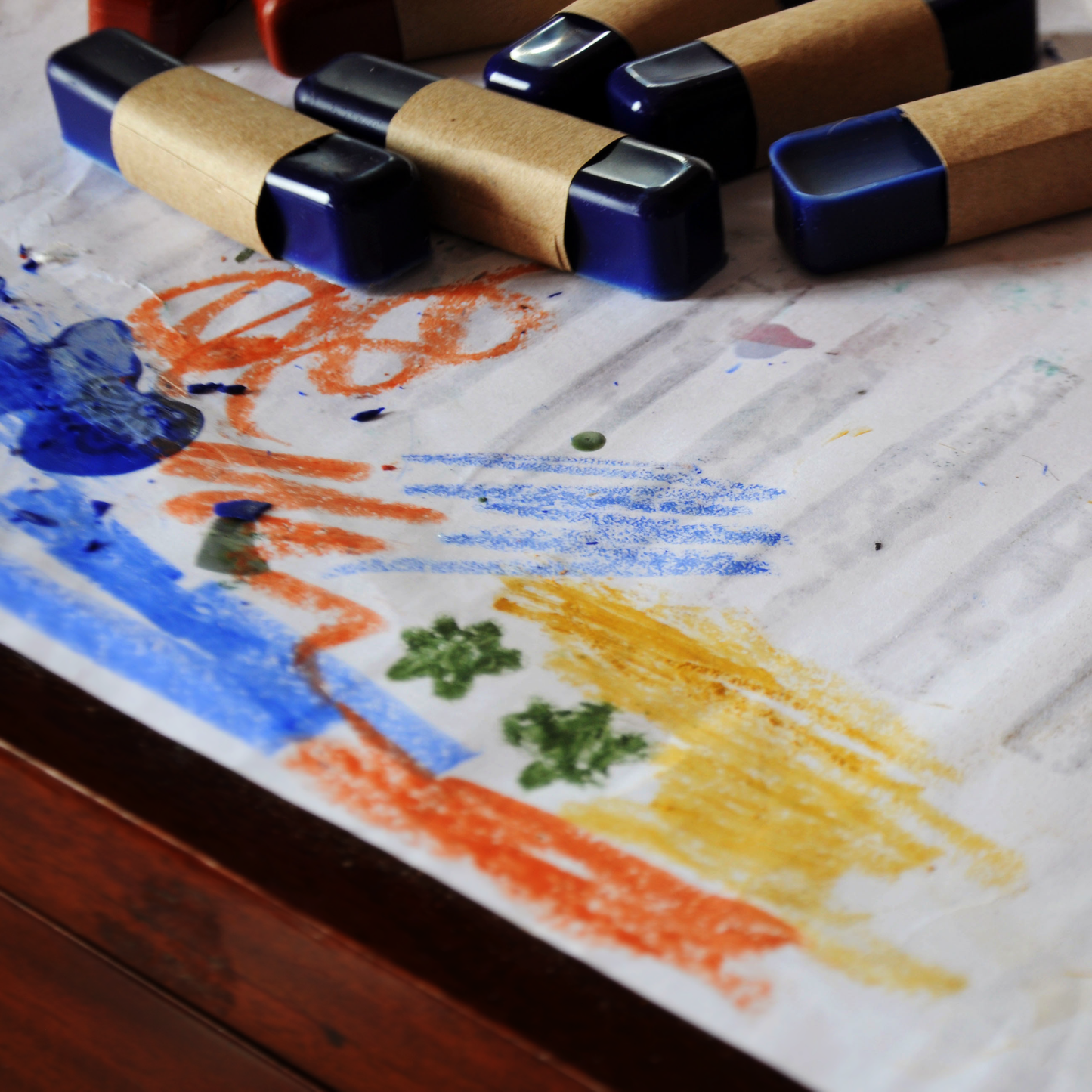 OIL PASTELS ALL NATURAL NONTOXIC ECO FRIENDLY on a table with some pastel scribbles on the side